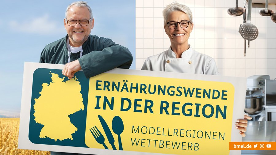Ein Mann und eine Frau halten ein Schild mit der Aufschrift "Ernährungswende in der Region - Modellregionenwettbewerb"